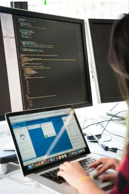 Una professionista davanti ai suoi schermi di lavoro