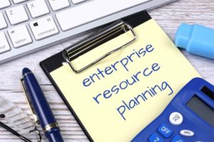 Bloc de notas con escrito enterprise resource planning en un escritorio