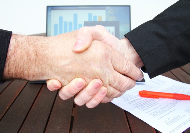 Due professionisti che si stringono la mano su una scrivania
