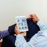Business professional-analyzing-integrated-crm-project Man in a pinstriped shirt using a white iPad in an office setting