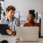 Due giovani colleghi che lavorano insieme in un ufficio moderno Due colleghi che lavorano