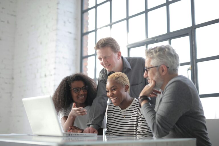 A group of colleagues laughing together in their office