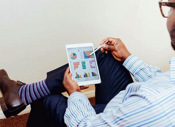 Man in a pinstriped shirt using a white iPad in an office setting