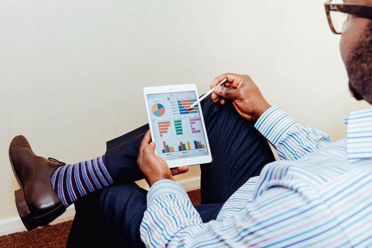 Business professional-analyzing-integrated-crm-project Man in a pinstriped shirt using a white iPad in an office setting