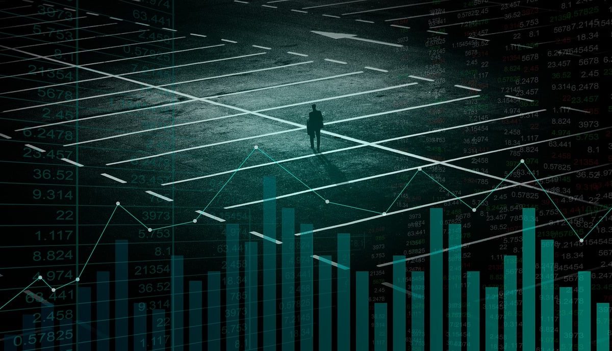 person-standing-at-a-crossroad Person standing at a crossroad overlaid with financial charts and data