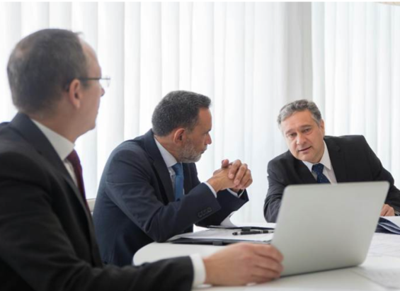Uomini professionisti che collaborano con un laptop in un ufficio moderno