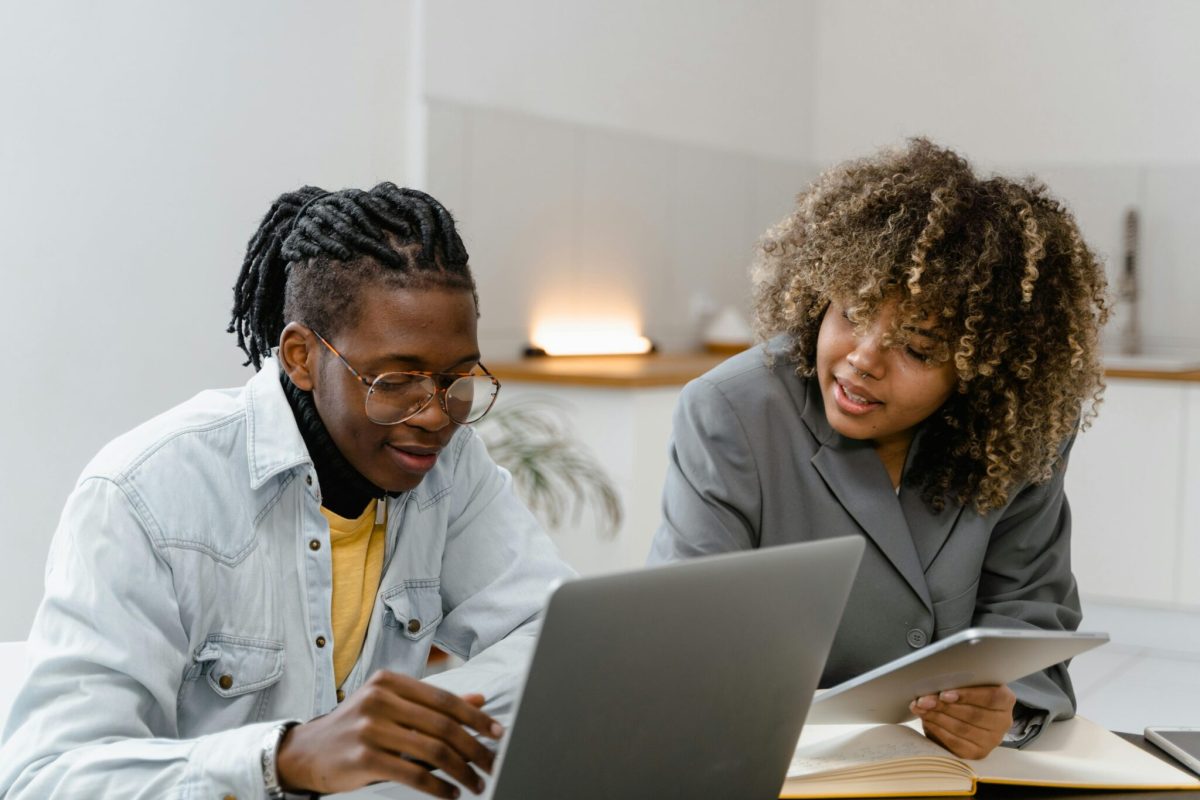 Two employees working together with a laptop and a tablet