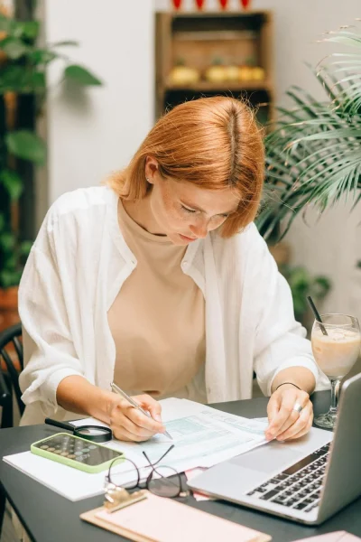 Young woman concentrating on analyzing documents at her desk