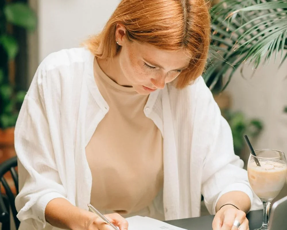 une-comptable-analysant-les-donnees-de-facturation Jeune femme concentrée sur l’analyse de documents à son bureau